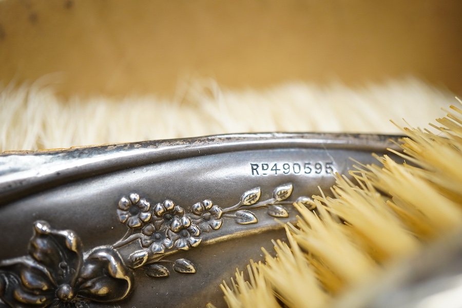 An Edwardian repousse silver mounted six piece dressing table mirror, brush and comb set, by Henry Matthews, Birmingham 1901, together with one other silver mounted hair brush and clothes brush.